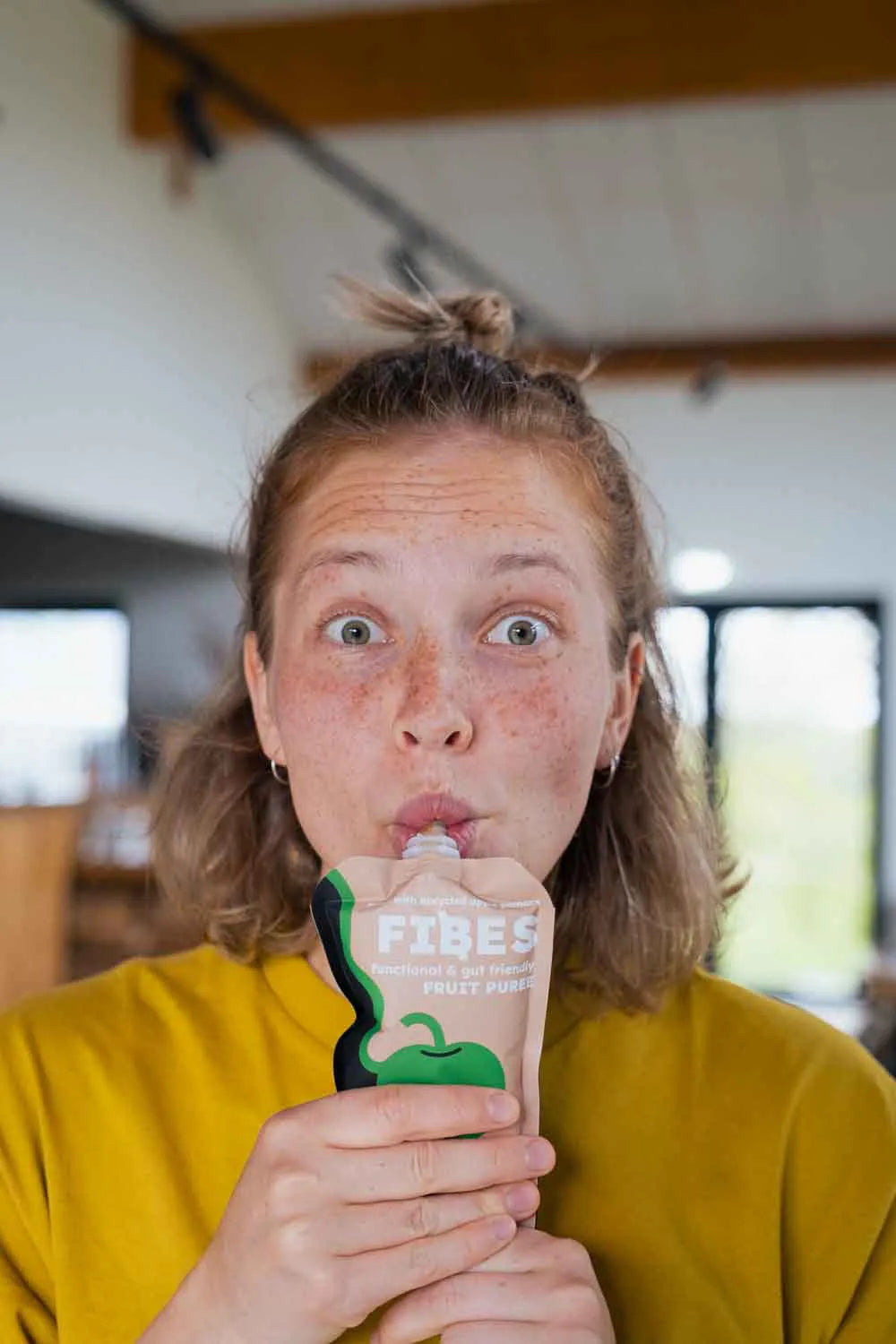 Person holding a FIBES puree in a casual setting