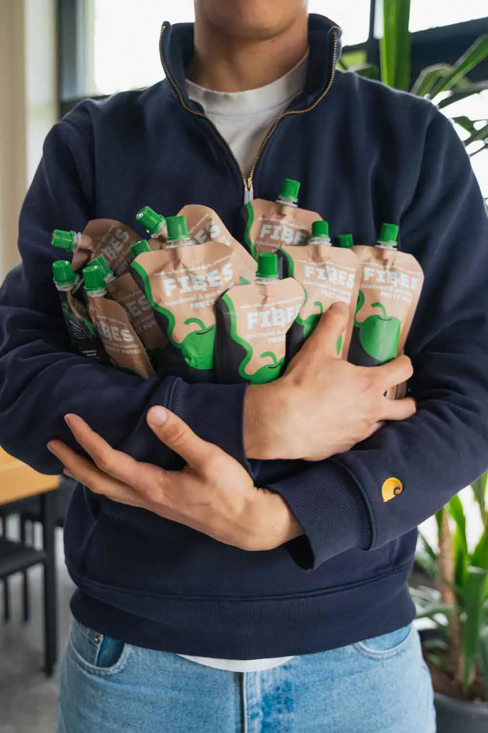 Person holding multiple pouches of Fibes in a casual setting